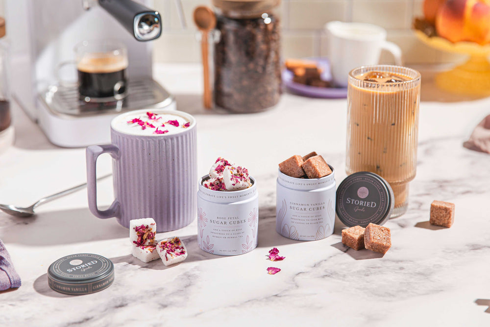 Coffeeshop setting with coffee cups, a coffee machine, and various treats on a marble surface.