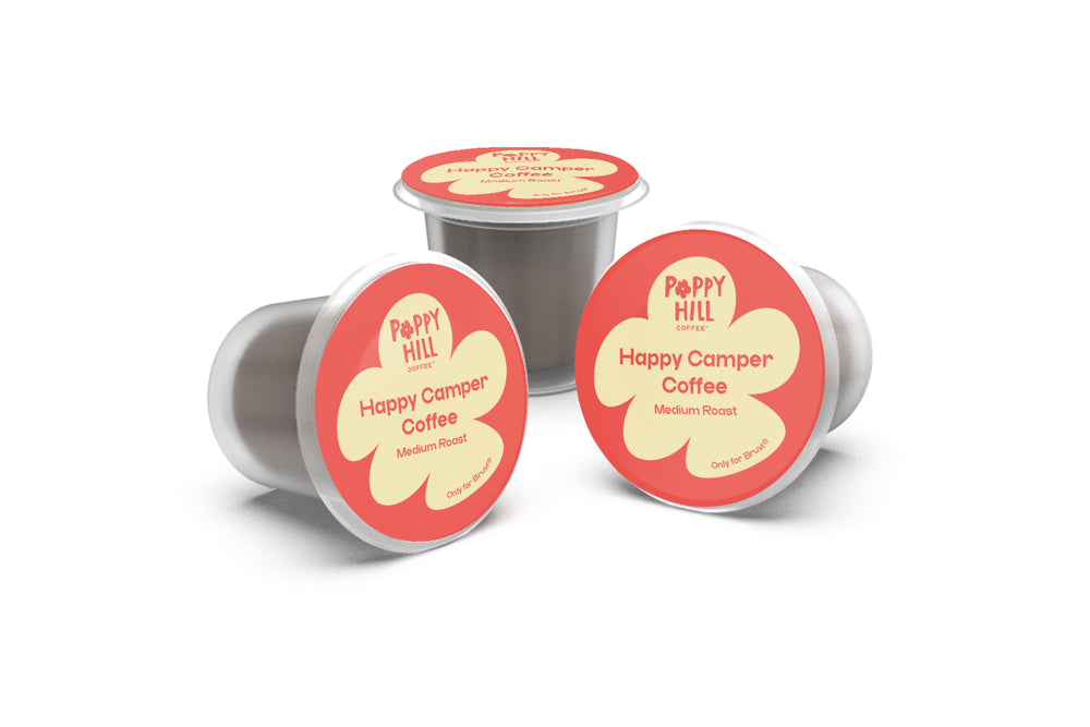 Three Happy Camper Coffee capsules on a white background